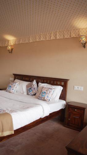 a bedroom with a large bed with pillows on it at Bikaner Desert Camp and Resort in Bikaner