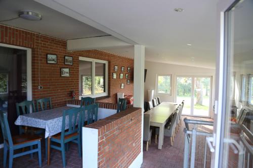a dining room with a table and chairs and a brick wall at Ottos Ferienhäuser in Rabenkirchen-Faulück