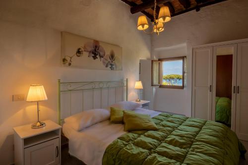 una camera da letto con un grande letto con una coperta verde di Tenuta La Chiusa a Portoferraio
