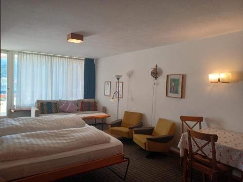 サンモリッツにあるAllod Bad 602のベッド、テーブル、椅子が備わるホテルルームです。