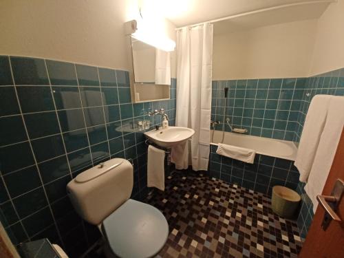 a bathroom with a toilet and a sink and a tub at Allod Bad 602 in St. Moritz