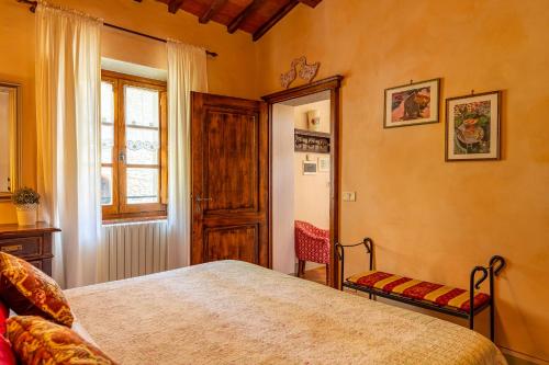 a bedroom with a bed and a window at Borgo Dolci Colline Resort Cipresso in Castiglion Fiorentino