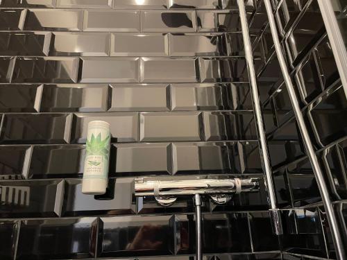a bathroom with a wall of black and white tiles at Designhotel Central Fulda in Fulda