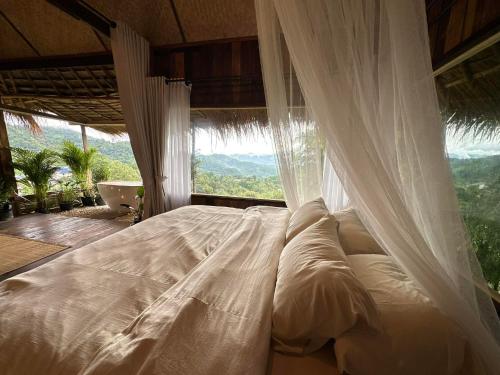 a bed in a room with a large window at Wanna’s house in Ban Huai Khai