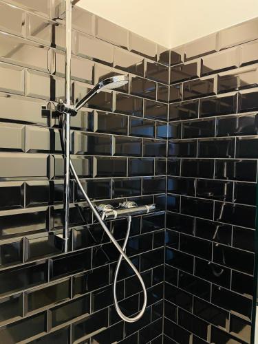 a shower in a black and white brick wall at Designhotel Central Fulda in Fulda