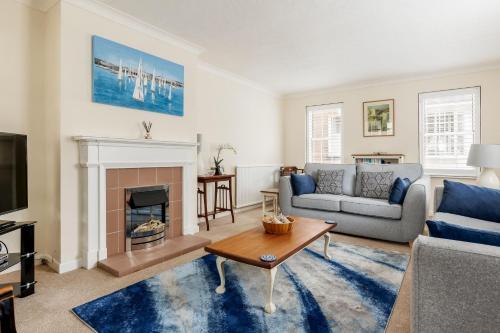 uma sala de estar com um sofá e uma lareira em Chimneys em Poole