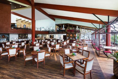une salle à manger avec des tables et des chaises en bois dans l'établissement Manas Lifestyle Resort, Igatpuri, à Igatpuri