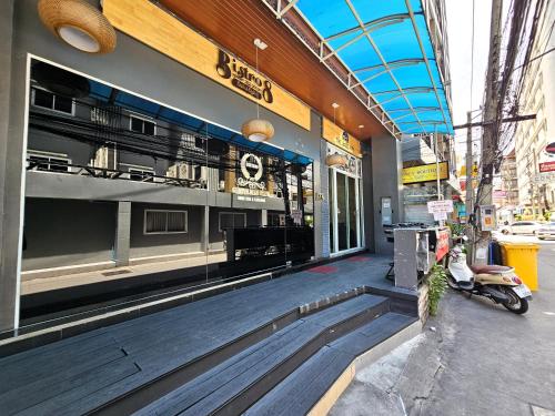 a store front with a motorcycle parked outside of it at The Base Inn Pattaya in Pattaya Central