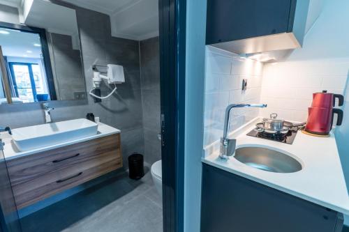 a bathroom with a sink and a toilet and a mirror at Yusufhan Suites in Trabzon