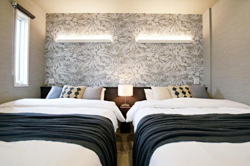 two beds sitting next to each other in a bedroom at The Masters Stay SETAGAYA KYODO in Tokyo