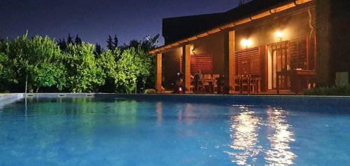 una casa con piscina por la noche en Dar Khedija en El Kheriba