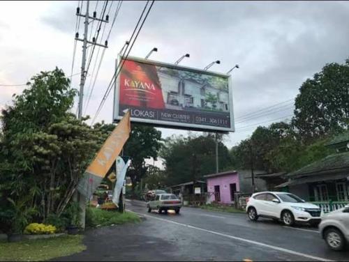 a billboard on the side of a road with cars at Villa Kayana Regency F9 Batu in Karangploso