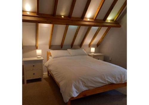 a bedroom with a white bed with two night stands at Bishops Farm in Thornbury