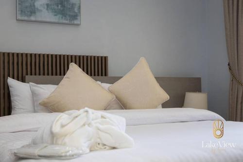een slaapkamer met 2 bedden met witte lakens en kussens bij Standard Room in Cape Coast - Lakeview by Agnes in Cape Coast