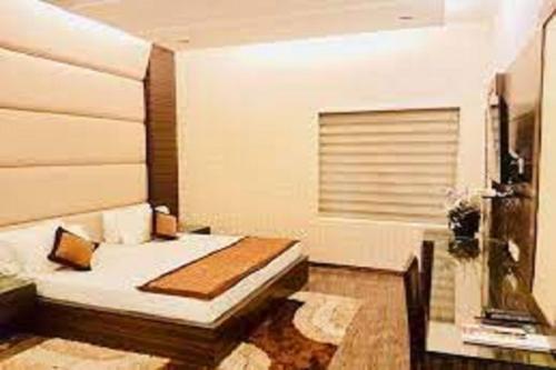 1 dormitorio con cama y ventana en Hotel Riya Palace By Standards, en Haldwāni