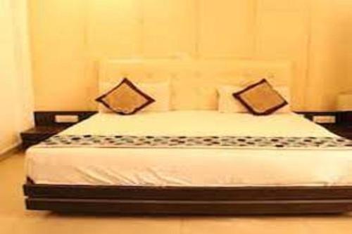 a bedroom with a bed with two pillows on it at Hotel Riya Palace By Standards in Haldwāni