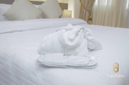 a white towel sitting on top of a bed at Standard Room in Cape Coast - Lakeview by Agnes in Cape Coast