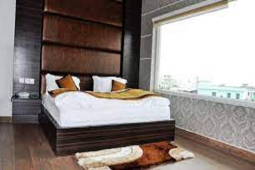 a bedroom with a large bed and a window at Hotel Riya Palace By Standards in Haldwāni