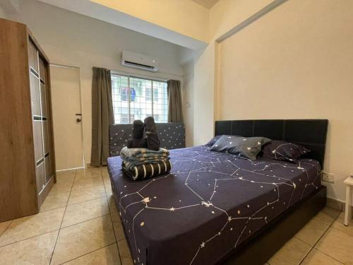 1 dormitorio con 1 cama grande y edredón azul en KK City A2Z Api Api Cozy Studio Homestay, en Kota Kinabalu