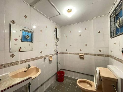 y baño con lavabo, aseo y espejo. en KK City A2Z Api Api Cozy Studio Homestay, en Kota Kinabalu