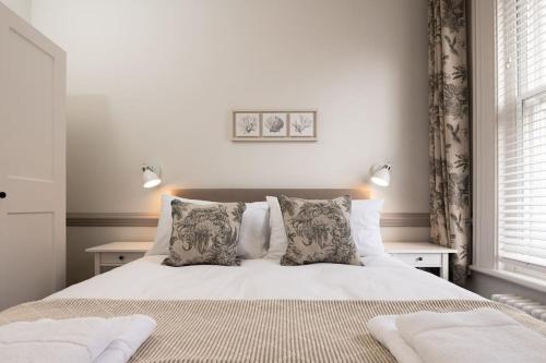 a bedroom with a white bed with two pillows at 3 Castle Mews in Salisbury