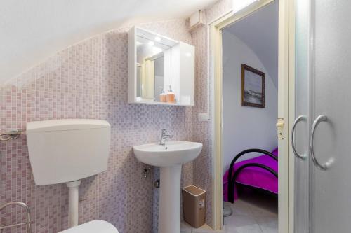 La salle de bains est pourvue d'un lavabo, de toilettes et d'un miroir. dans l'établissement Dimora degli Angeli by BarbarHouse, à Gallipoli
