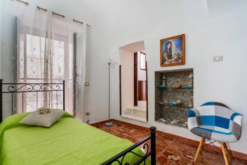 - une chambre avec un lit vert et une fenêtre dans l'établissement Dimora degli Angeli by BarbarHouse, à Gallipoli