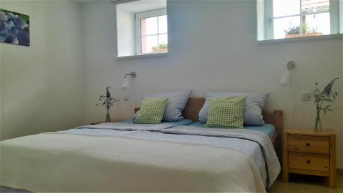 a bed with two green pillows in a bedroom at Ferienwohnungen "Zum Lochfeld" in Wittersheim