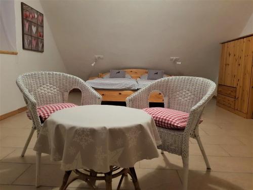 a dining room with a table and chairs with a table at Ferienwohnungen "Zum Lochfeld" in Wittersheim