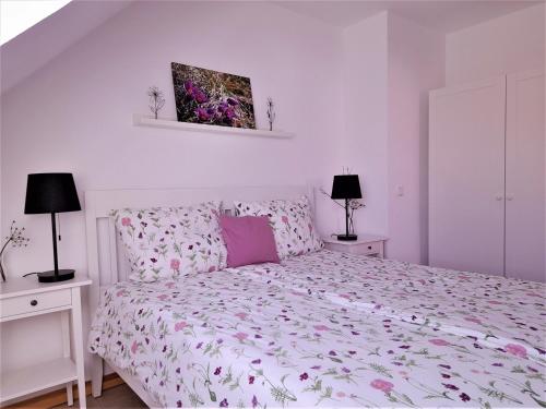 a bedroom with a bed and two night stands and two lamps at Ferienwohnungen "Zum Lochfeld" in Wittersheim