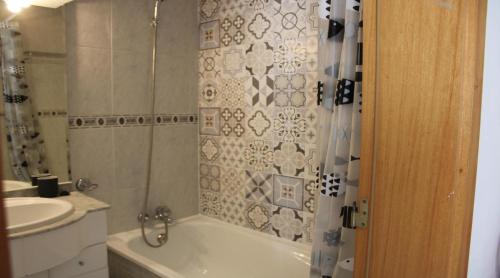 a bathroom with a bath tub and a sink at Casa Jardins da Rocha in Portimão