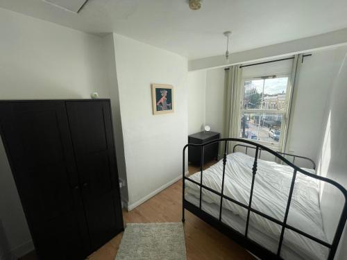 a bedroom with a black bed and a window at Islington Apartments in London
