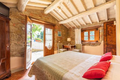 1 dormitorio con 1 cama grande con almohadas rojas en Dolci Colline Resort Capannina, en Castiglion Fiorentino