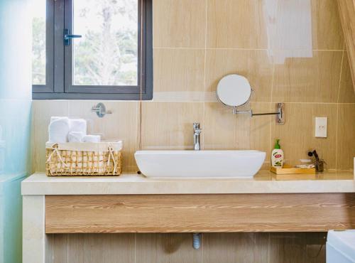 a bathroom with a sink and a mirror at Đá Góc Nhà Boutique Hotel in Da Lat