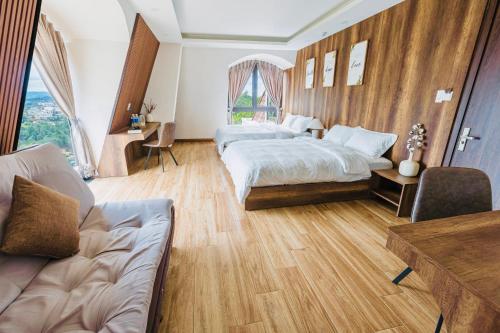 a large bedroom with a bed and a couch at Đá Góc Nhà Boutique Hotel in Da Lat