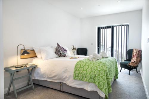 a bedroom with a large bed with a green blanket at Fulmar in Torpoint