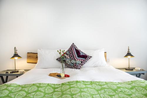 a white bed with a green and white comforter at Fulmar in Torpoint
