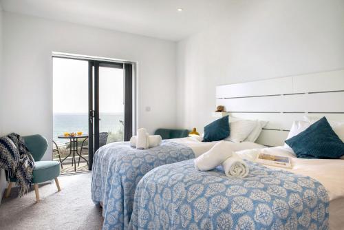 a bedroom with two beds and a view of the ocean at Fulmar in Torpoint