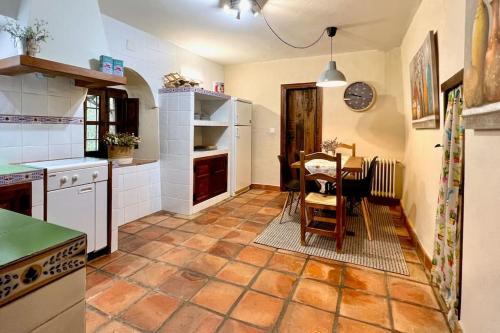 a kitchen with a table and a dining room at Casa Rural La Cordonera in Herguijuela