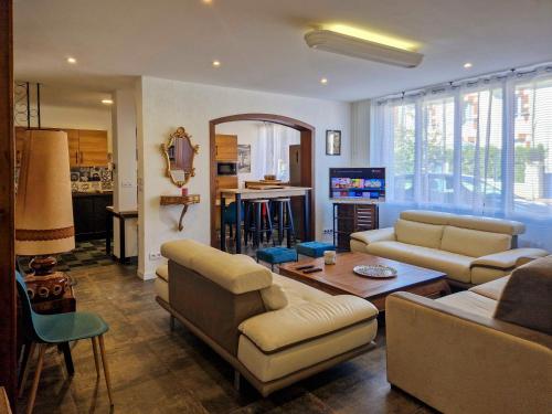 a living room with a couch and a table at Magnifique maison classée 3 étoiles, 7 chambres, 5 salles de bain, parking privé, Tarbes ville in Tarbes