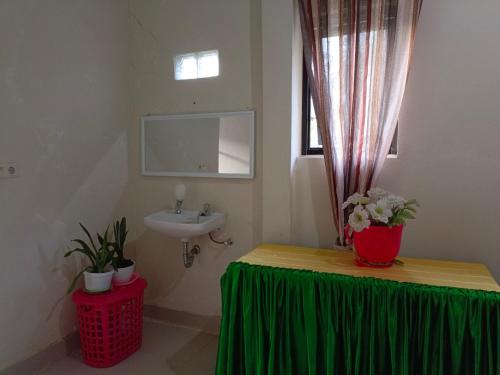 een badkamer met een groene tafel en een wastafel bij Helens Homestay in Enrekang