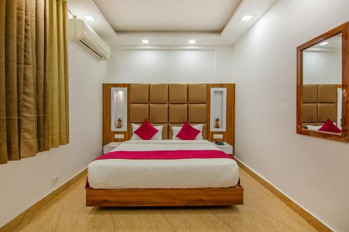 a bedroom with a large bed with red pillows at Rahul Palace By Golden Tree in New Delhi