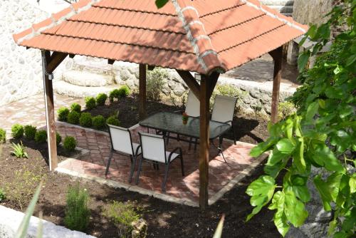 cenador con mesa y sillas en el jardín en Villa Andrea Apartments with parking, en Kotor