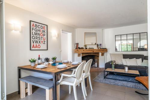 une salle à manger avec une table et des chaises et une cheminée dans l'établissement Le Petit Moulleau - Appt dans villa classée à 50m de la plage, à La Teste-de-Buch