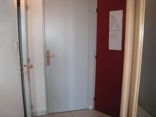 une porte rouge et blanche avec un panneau sur elle dans l'établissement Appartement ensoleillé pour 5 pers, balcon sud, proche remontées et commerces, animaux acceptés - FR-1-405-94, à L'Alpe-d'Huez