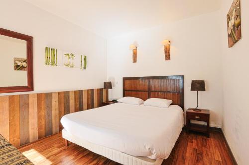 a bedroom with a large white bed and a mirror at Hôtel François d'O in Caen