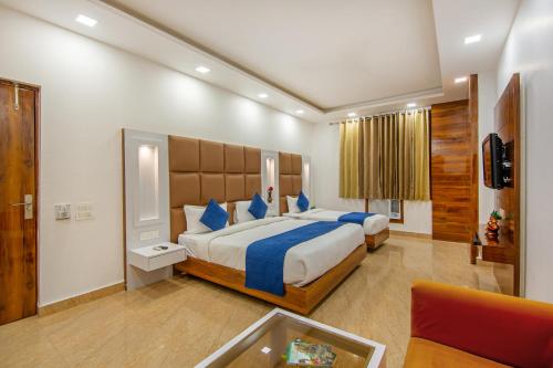 a large bedroom with a large bed and a couch at Rahul Palace By Golden Tree in New Delhi