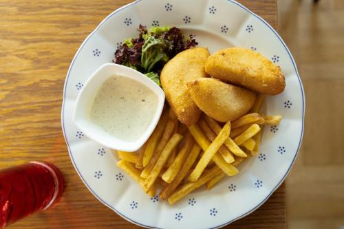 a plate of food with fries and a dipping sauce at Hotel Zámeček Janovičky in Broumov