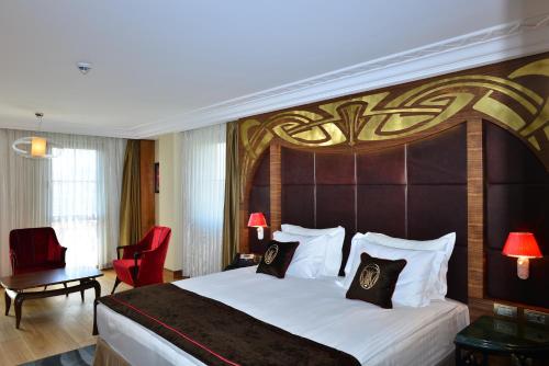 a hotel room with a large bed and a red chair at Warwick Ankara in Ankara