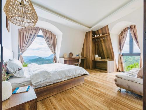 a bedroom with a bed and a large window at Đá Góc Nhà Boutique Hotel in Da Lat